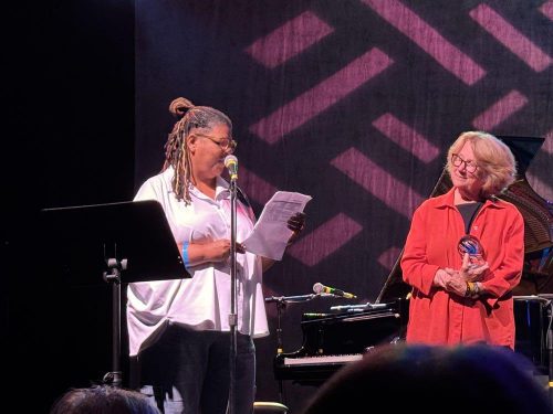 Holly receiving the 2026 Legacy Awared at the National Womens Music Festival